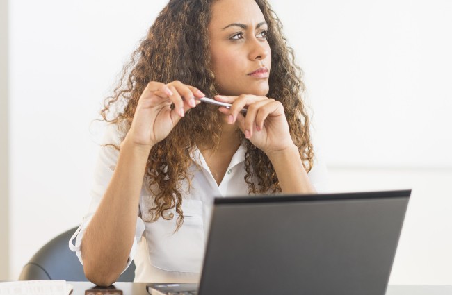 USA, New Jersey, Jersey City, Office worker sitting by desk with laptop