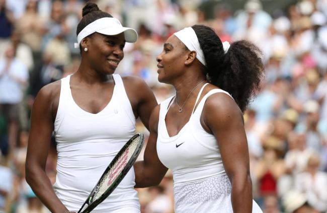 LONDON, ENGLAND - JULY 06: Venus Williams (USA) (L) embraces Sister, Serena (R) after defeat in the 4th round on day seven of the Wimbledon Lawn Tennis Championships at the All England Lawn Tennis and Croquet Club on July 06, 2015 in London, England. (Photo by Marc Atkins/Mark Leech/Getty Images)