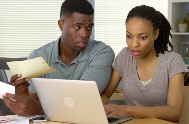 Serious young African American couple making bill payments online